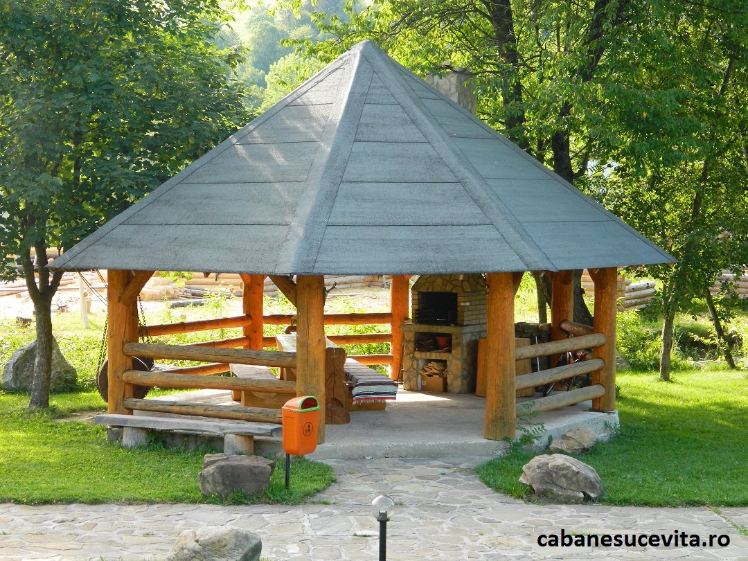 Foișor hexagonal din bușteni, pe iarbă