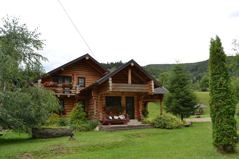 Cabană din lemn într-o grădină îngrijită
